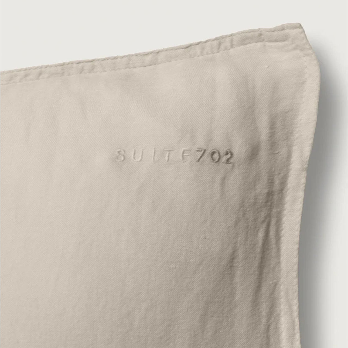 Nahaufnahme des eingeprägten „Suite702“-Schriftzugs auf dem Leinen-Mix Kissenbezug in Dune