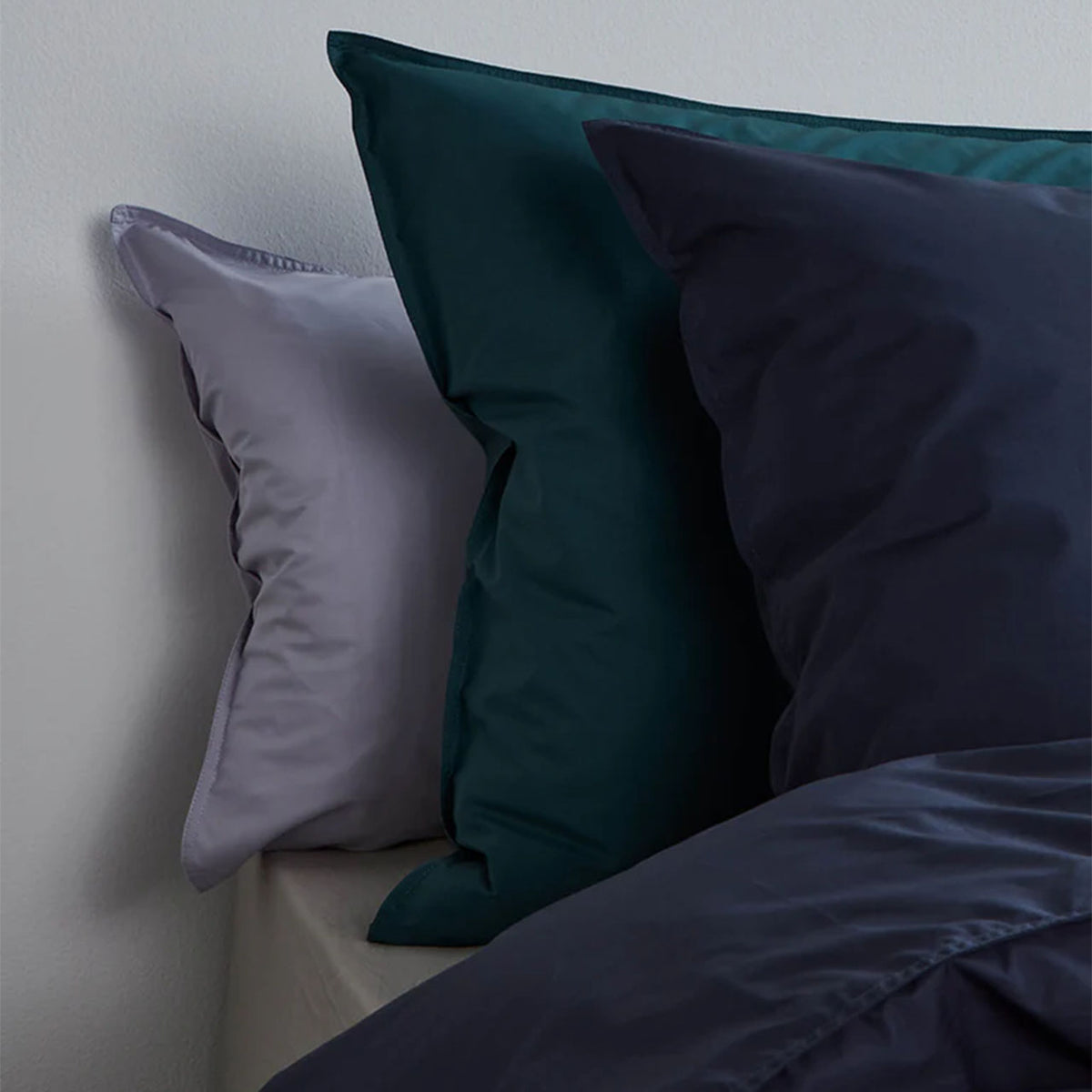 Suite702 Perkal Kissenbezüge aus Bio-Baumwolle in Grau, Petrol und Marineblau auf dem Bett