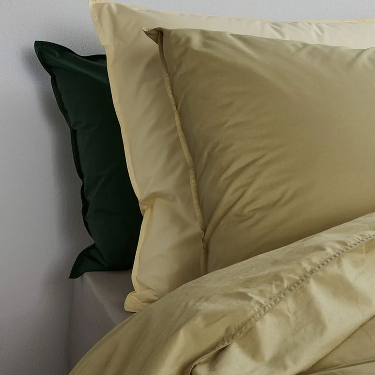Suite702 Perkal Kissenbezüge aus Bio-Baumwolle in Gelb und Dunkelgrün, Nahaufnahme auf dem Bett